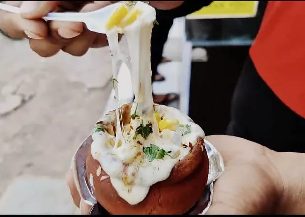 A chef making kullhad pizza